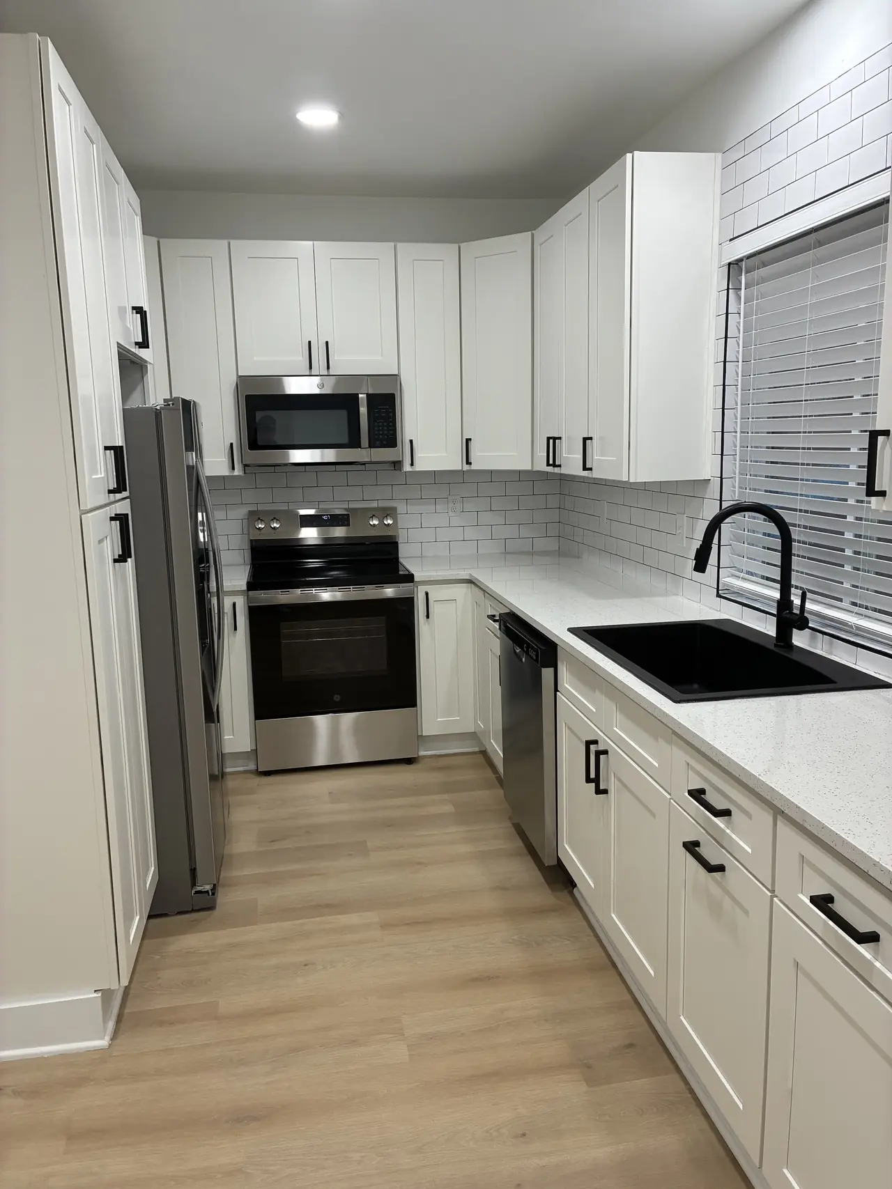 Renovated kitchen with white shaker cabinets, stainless appliances, and a subway tile backsplash